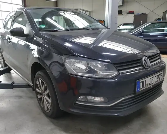 Dunkelgrauer Volkswagen Polo steht in einer hellen Kfz-Werkstatt zur Inspektion.